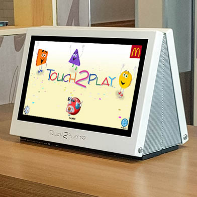 Kidzpace 15" Touch2Play Pro touch screen game cabinets mounted back to back on a table
