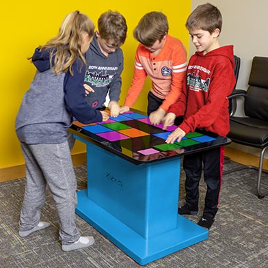 Four kids playing a game of "Bloop" on the Touch2Play Table.