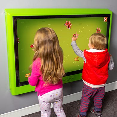 Children playing touch screen games together on the Touch2Play Junior Wall interactive play wall