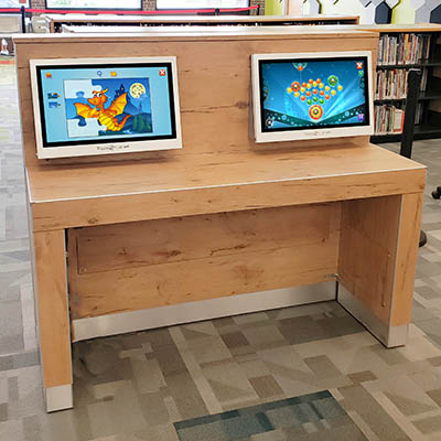 Touch2Play touchscreen game kiosk mounted to a drop in wall and counter at the library