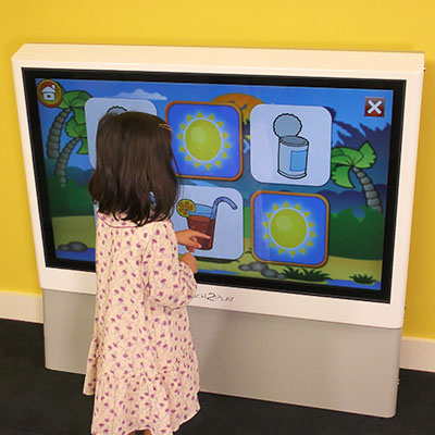 Child playing a memory game on the interactive play wall touch screen game cabinet