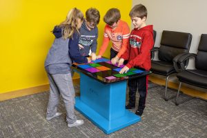 4 kids playing a game on the Touch2Play Table.